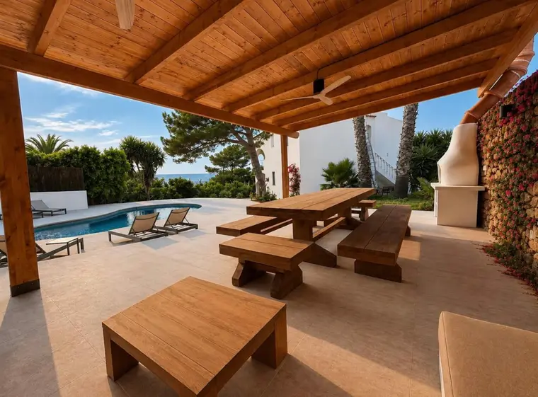 Pérgola de madera con mesa de comedor junto a la piscina